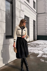 a lady in a white cardigan with black trim and a black dress